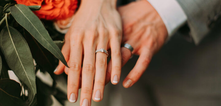 Married couple wearing a wedding and engagement ring covered by renters insurance