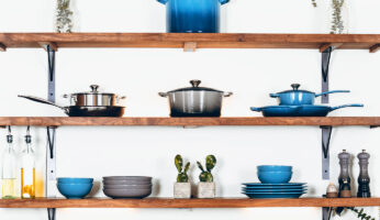 shelf above a sink with various cookware in a first apartment